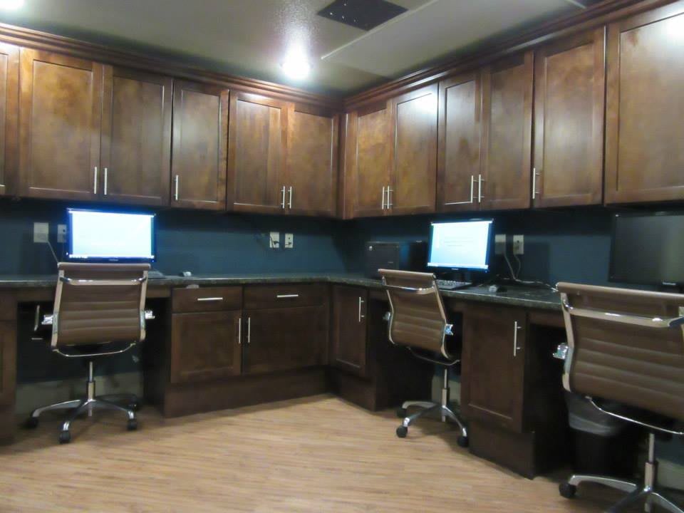 Modern office workspace with computers and wooden cabinets.