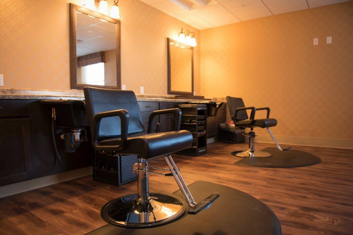Interior view of a modern barbershop with styling chairs and mirrors.