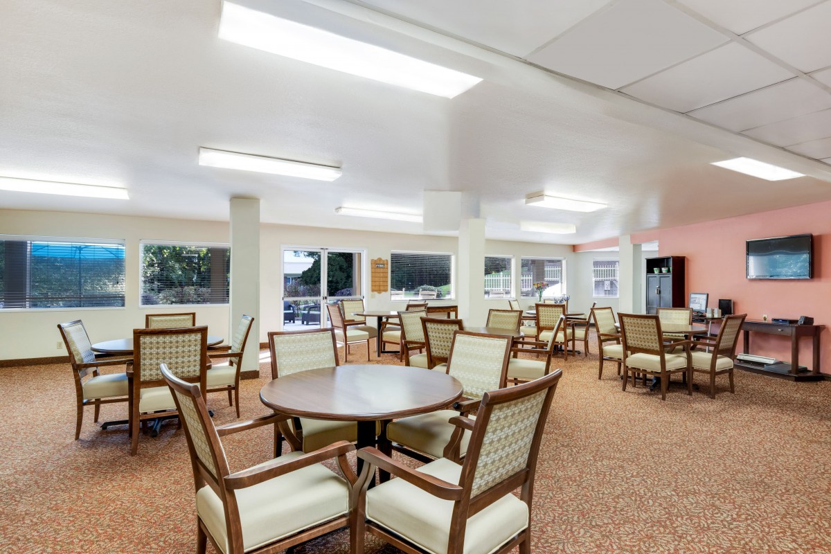 A spacious and well-lit dining area with multiple tables and chairs.