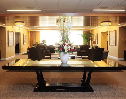 A hotel lobby with a table centerpiece and seating area.