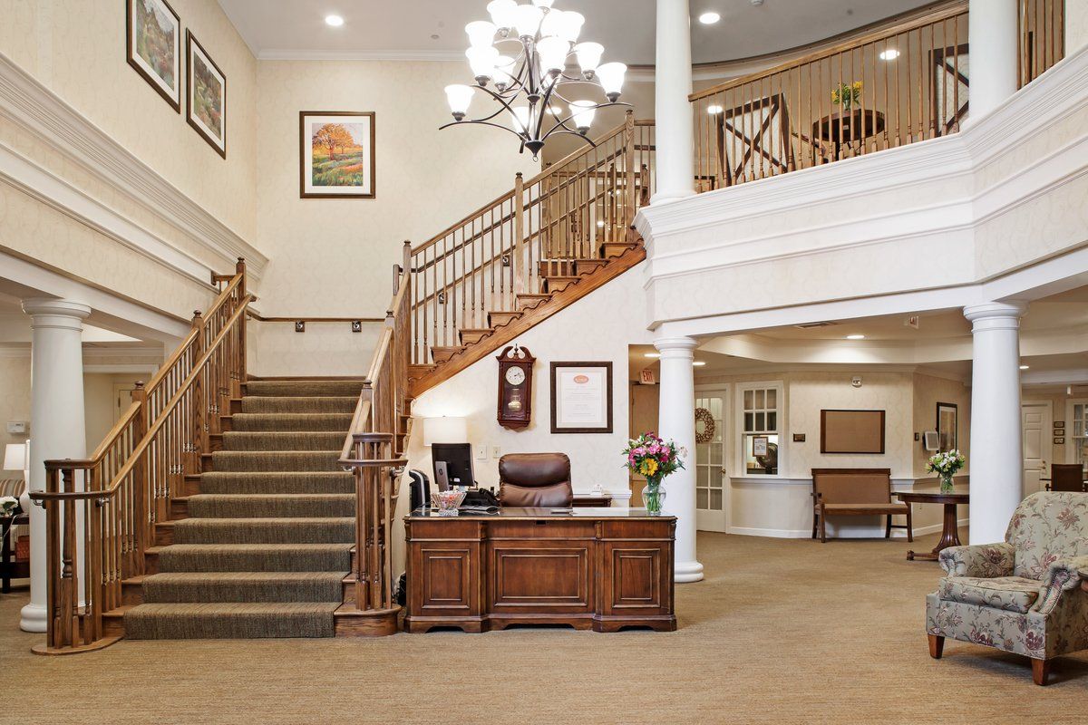 A welcoming hotel lobby with a grand staircase and elegant chandelier.