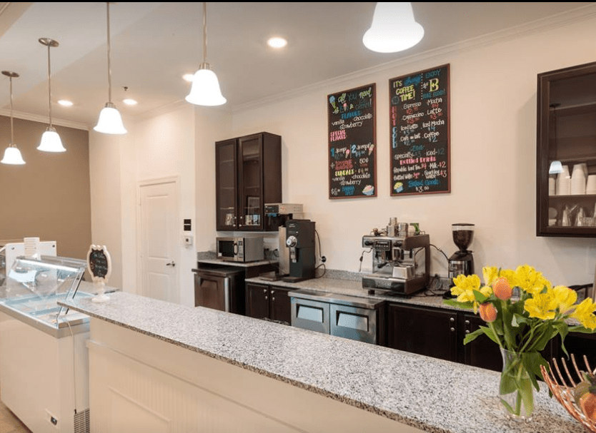 A modern coffee shop counter with espresso machines and menu boards.