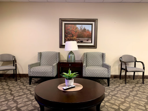 A cozy and inviting waiting area featuring comfortable chairs, a stylish coffee table, and decorative elements.
