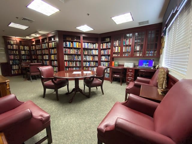 A cozy library with wooden bookshelves and comfortable seating.