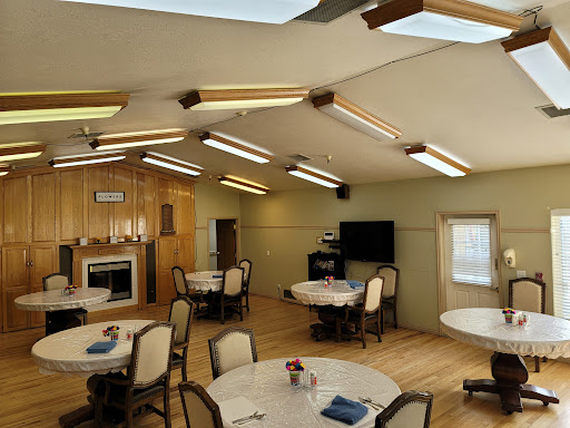 A cozy dining area featuring round tables, comfortable chairs, and plenty of natural light from skylights.
