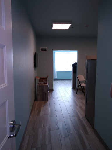 A view down a hallway in an office, showcasing a well-lit space with minimal furniture.