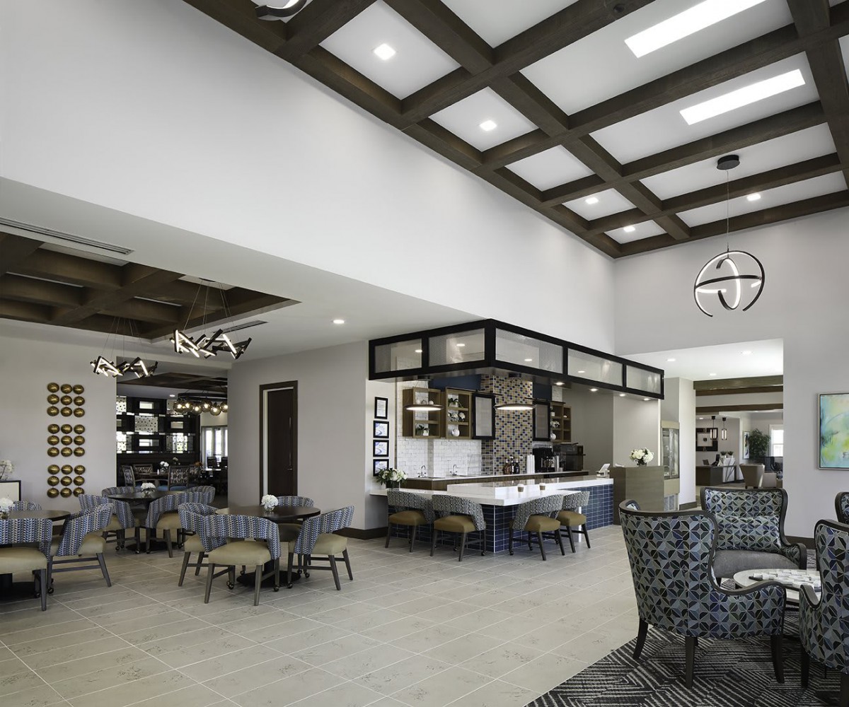 A modern and spacious cafe interior with a variety of seating options and stylish lighting.