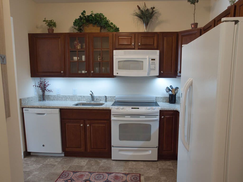 A modern kitchen with wooden cabinets and white appliances.
