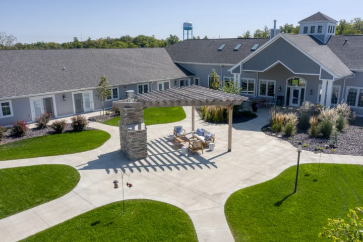 Aerial view of a landscaped outdoor patio with a pergola and seating area.