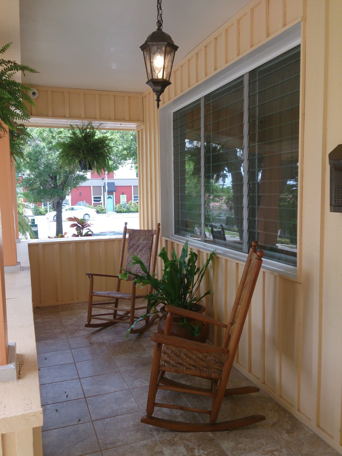 A cozy porch with rocking chairs and lush plants.