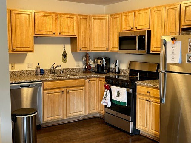 A modern kitchen with wooden cabinets and stainless steel appliances.