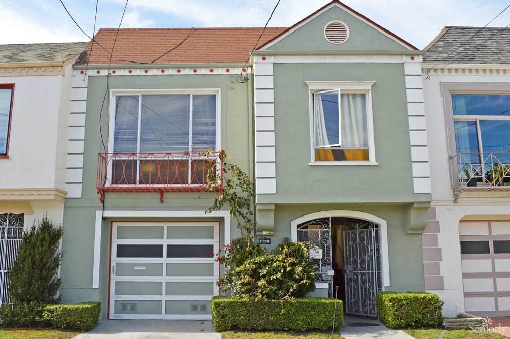A two-story house with a green facade and garage.