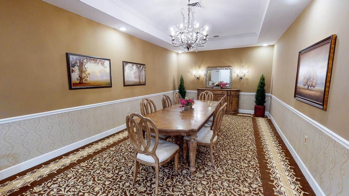 Elegant dining room with a chandelier, wooden dining set, and tasteful decor.