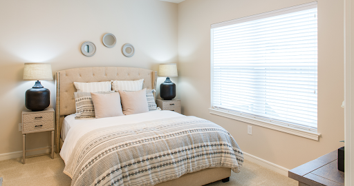 A serene and modern bedroom featuring soft tones, a plush bed, and natural light.
