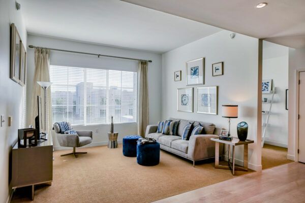 A well-lit living room with a sofa, armchair, and modern decor.