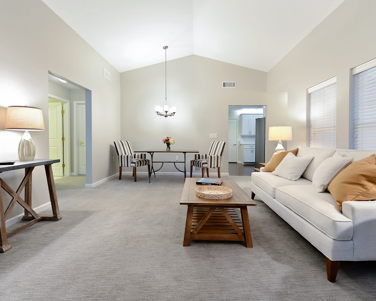 A spacious living room with a dining area, featuring modern decor and minimalist furniture.