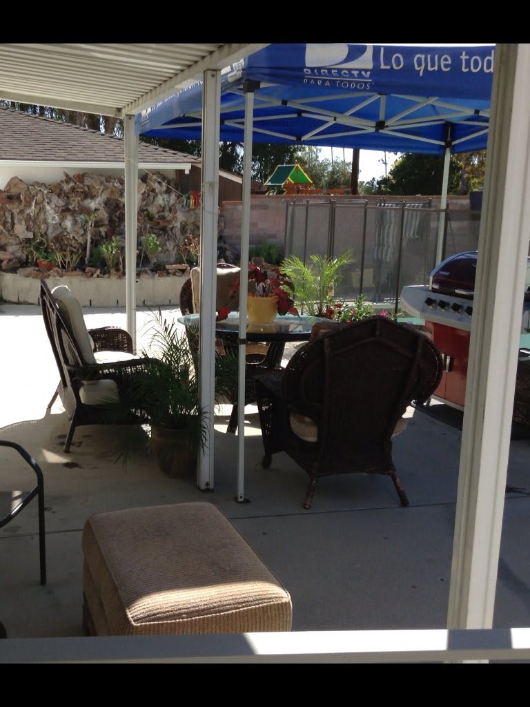 A cozy backyard patio with outdoor seating and a canopy.