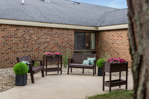 A cozy outdoor patio area featuring comfortable seating and vibrant flower arrangements.