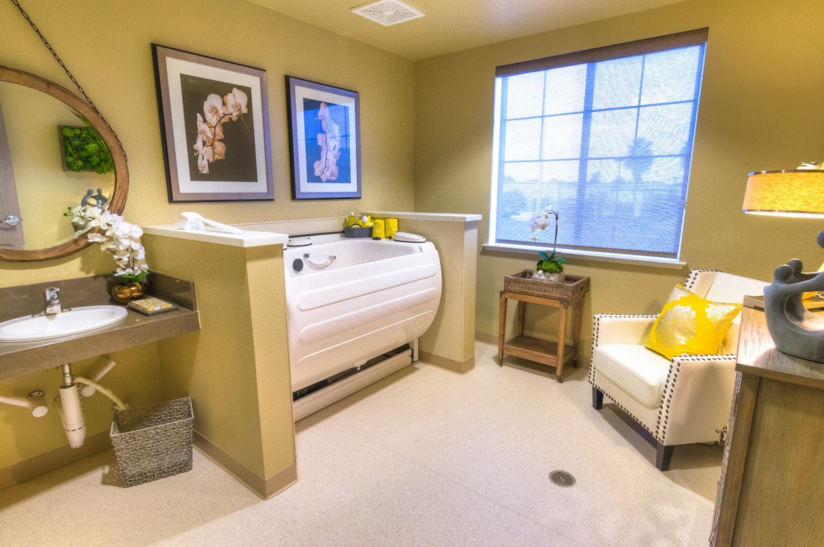 A cozy and modern bathroom with a built-in bathtub, stylish wall art, and comfortable seating.