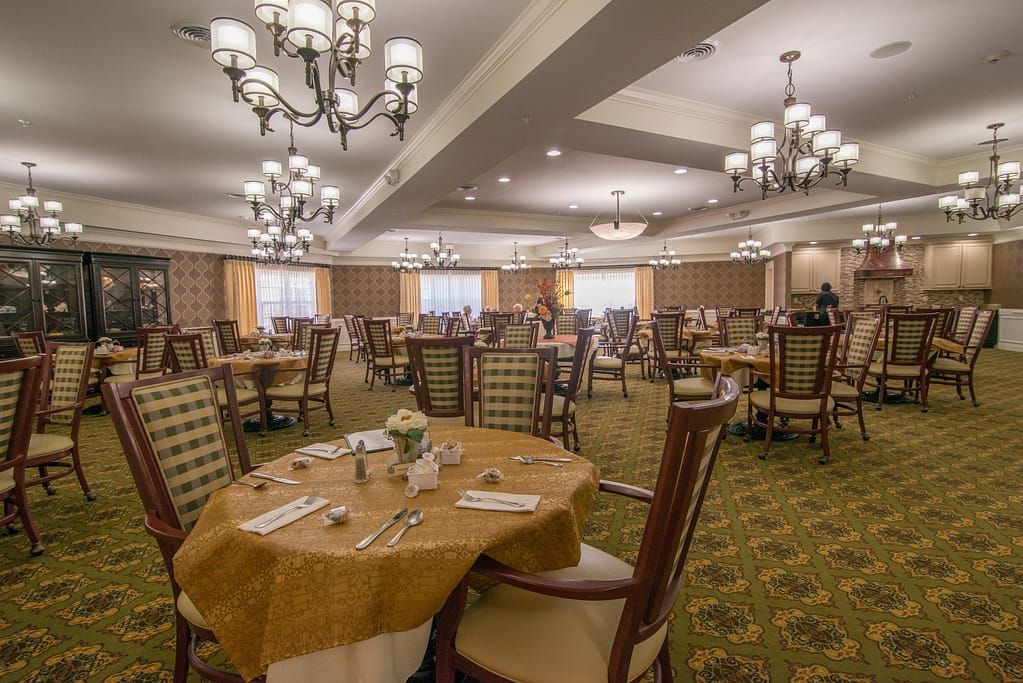 An elegant dining room with beautifully set tables and chandeliers.