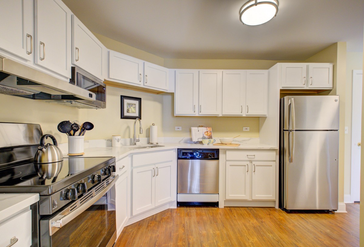 A modern kitchen with white cabinets and stainless steel appliances.