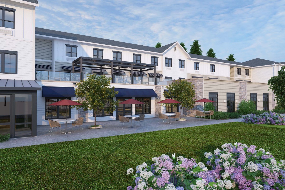 A modern hotel building with outdoor seating and landscaped gardens.