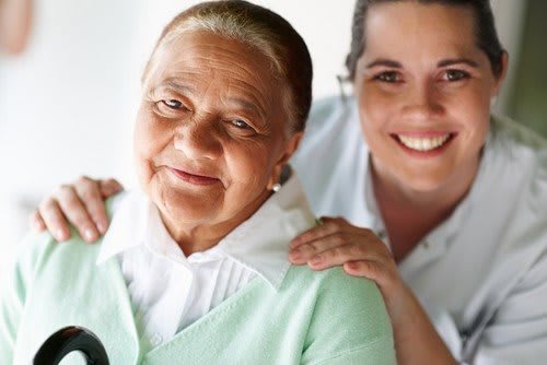 An elderly woman with a younger woman smiling and showing support.