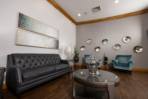 A modern waiting room featuring elegant furniture, decorative artwork, and a cozy ambiance.
