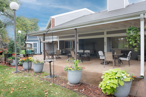 A serene outdoor patio space featuring comfortable seating and vibrant potted plants.