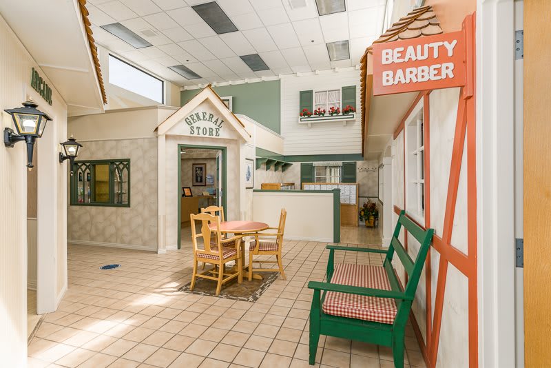 A vintage-themed interior with a mock beauty and barber shop setup, complete with tables and chairs.