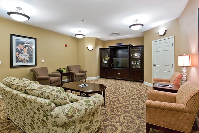A cozy lounge area with comfortable seating, a patterned carpet, and soft lighting.