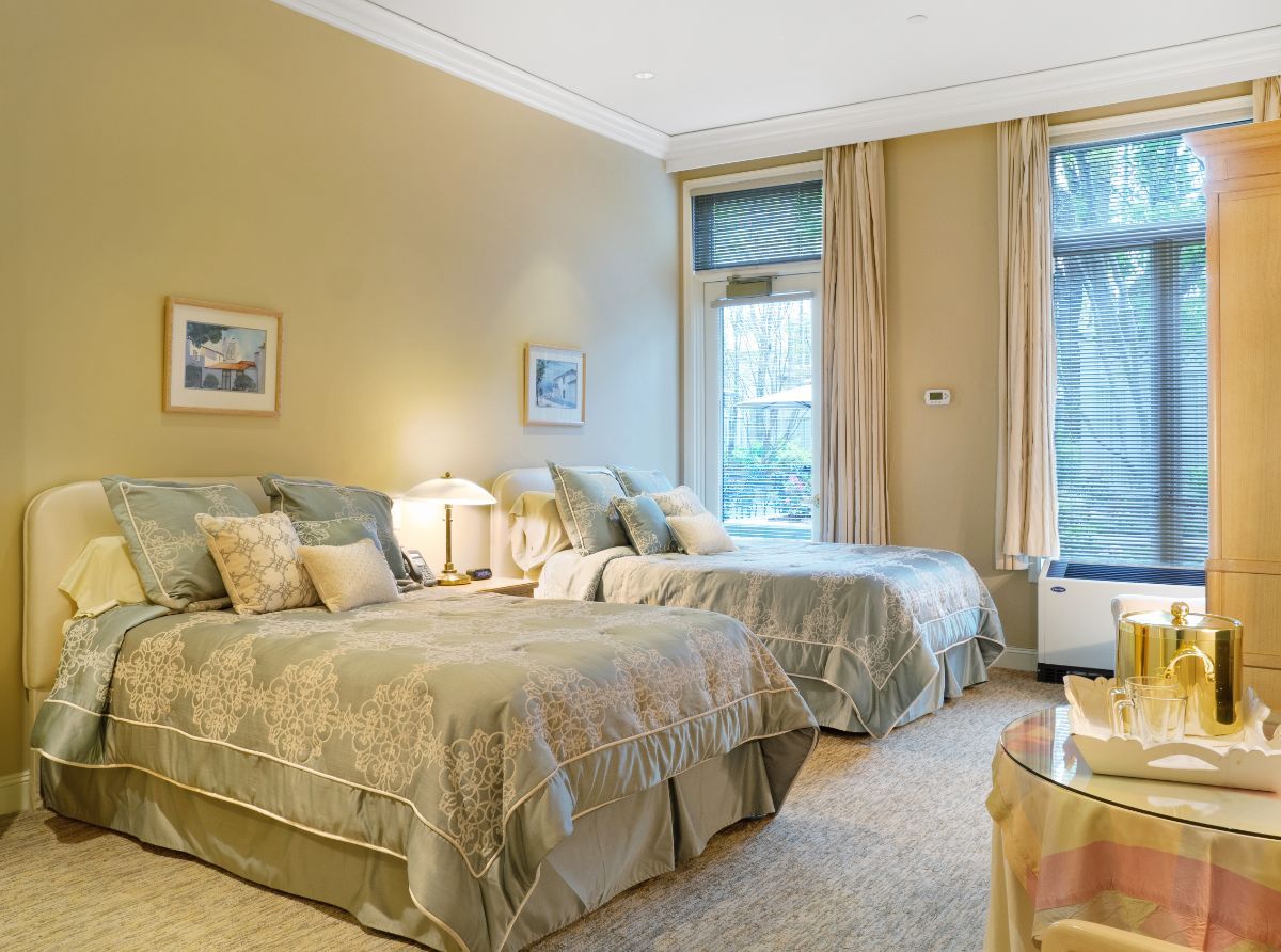 A cozy bedroom with two beds, warm lighting, and elegant decor.