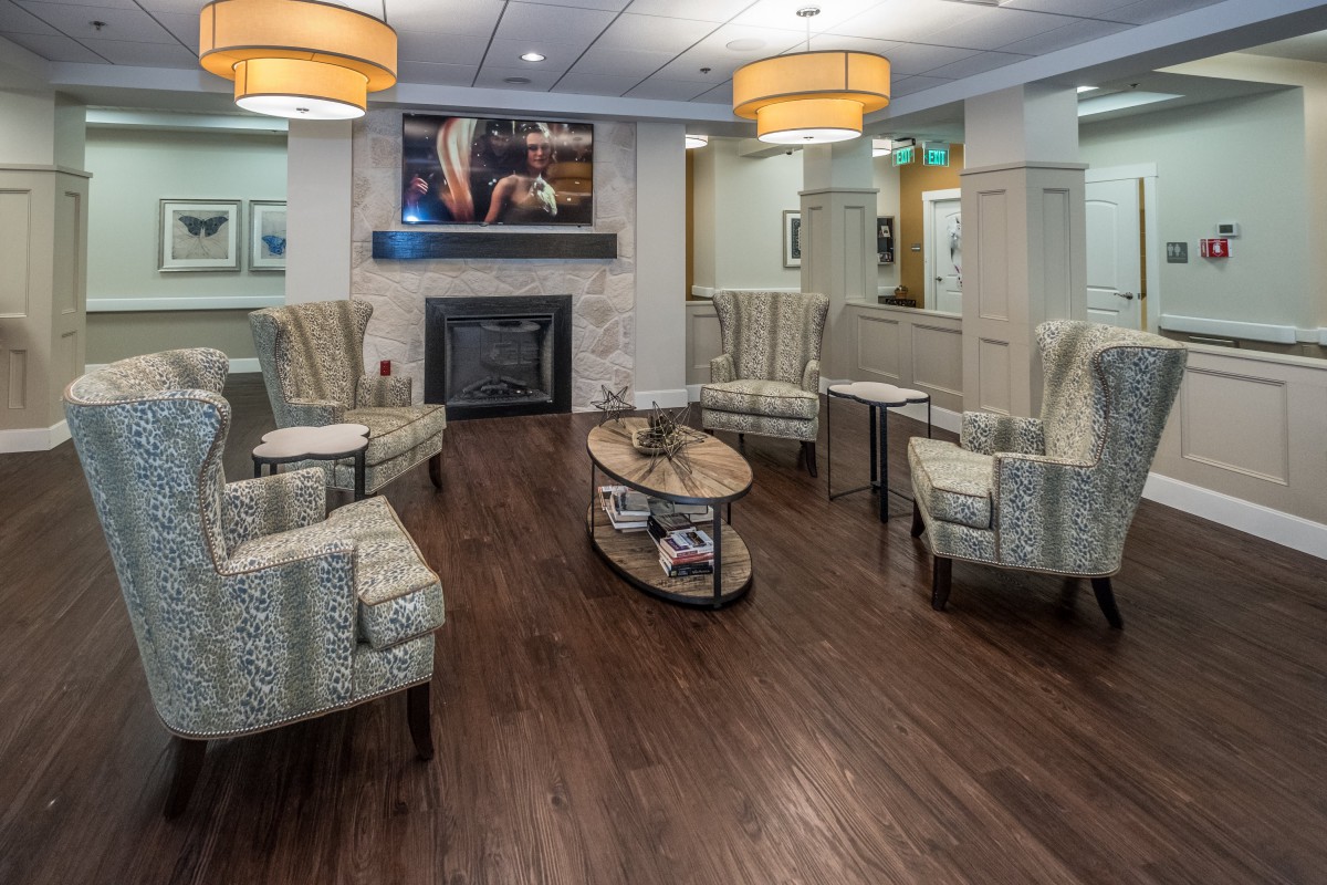 A cozy lobby seating area with comfortable chairs, a fireplace, and warm lighting.