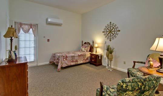 A cozy bedroom with a single bed, nightstand, and decorative elements on the wall.