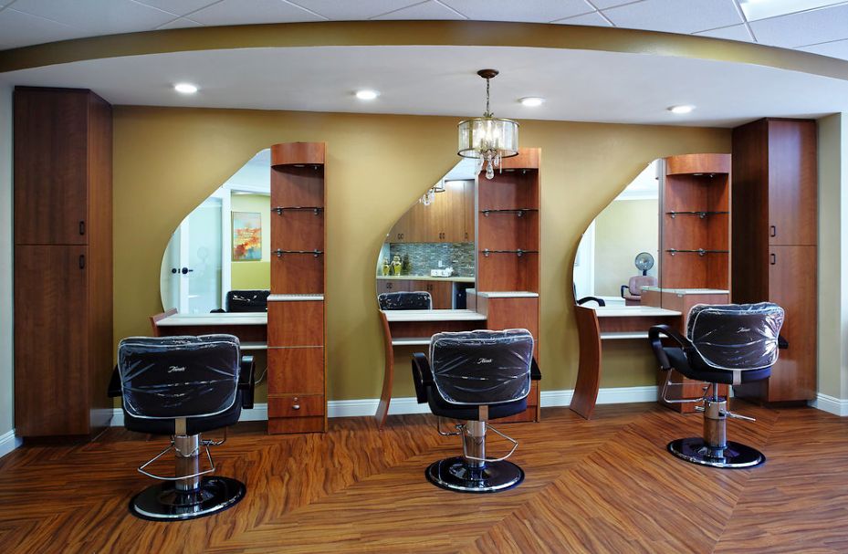 An interior view of a modern hair salon with styling chairs and mirrors.