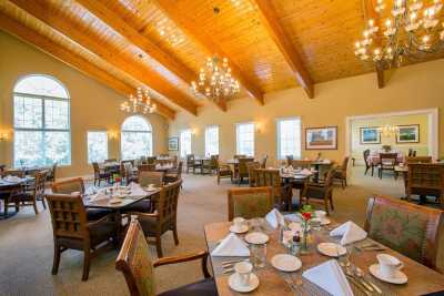 An elegant restaurant dining room with chandeliers and neatly set tables.
