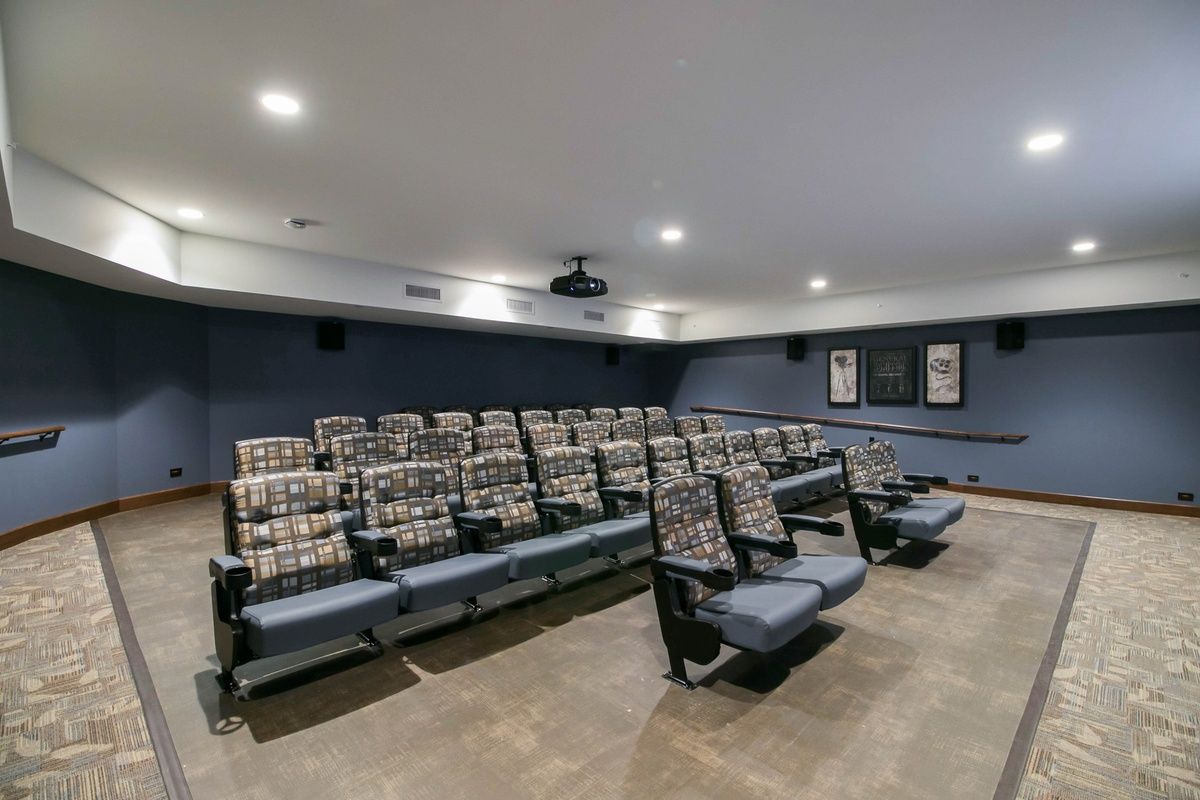 A well-equipped home theater featuring tiered seating and a central projector.
