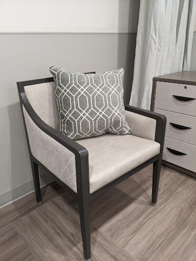 A stylish modern chair with a decorative pillow, perfect for home interiors.