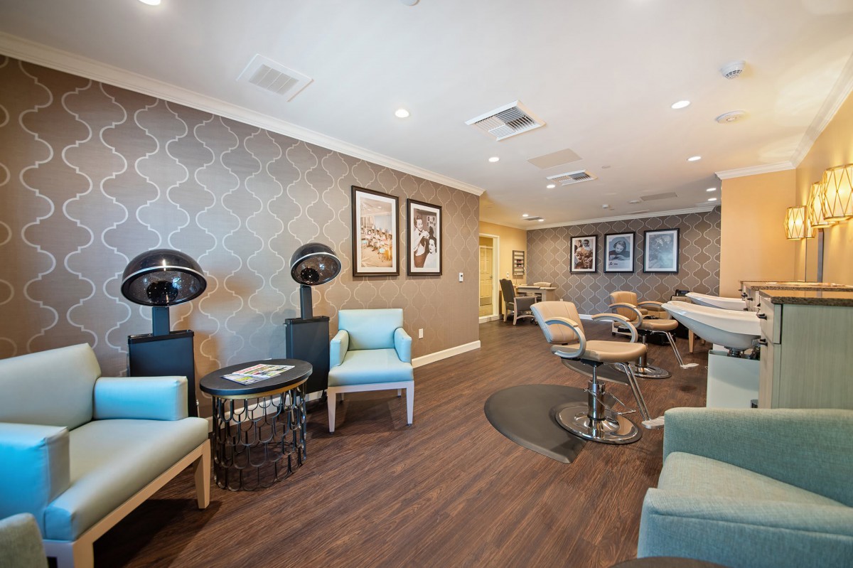 A stylish salon interior with seating, hair dryers, and decorative wall art.