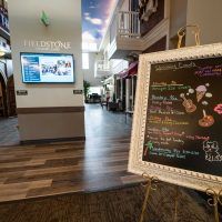 A cozy cafe menu board displayed in an indoor hallway setting.