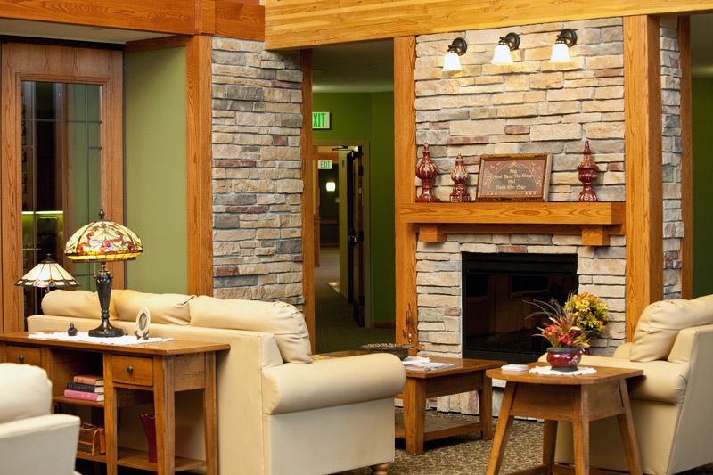 A cozy living room featuring a stone fireplace and wood accents.