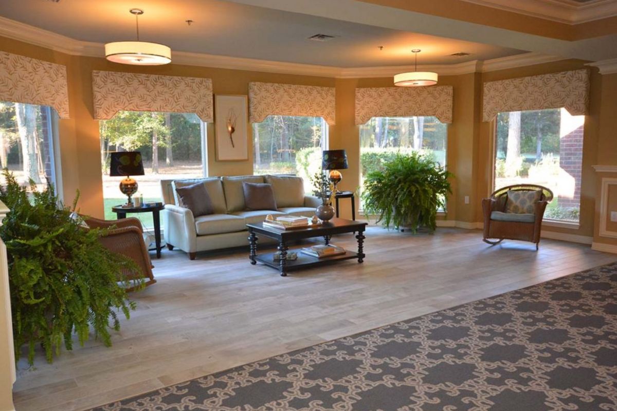 A spacious and elegantly decorated living room with large windows and comfortable seating.