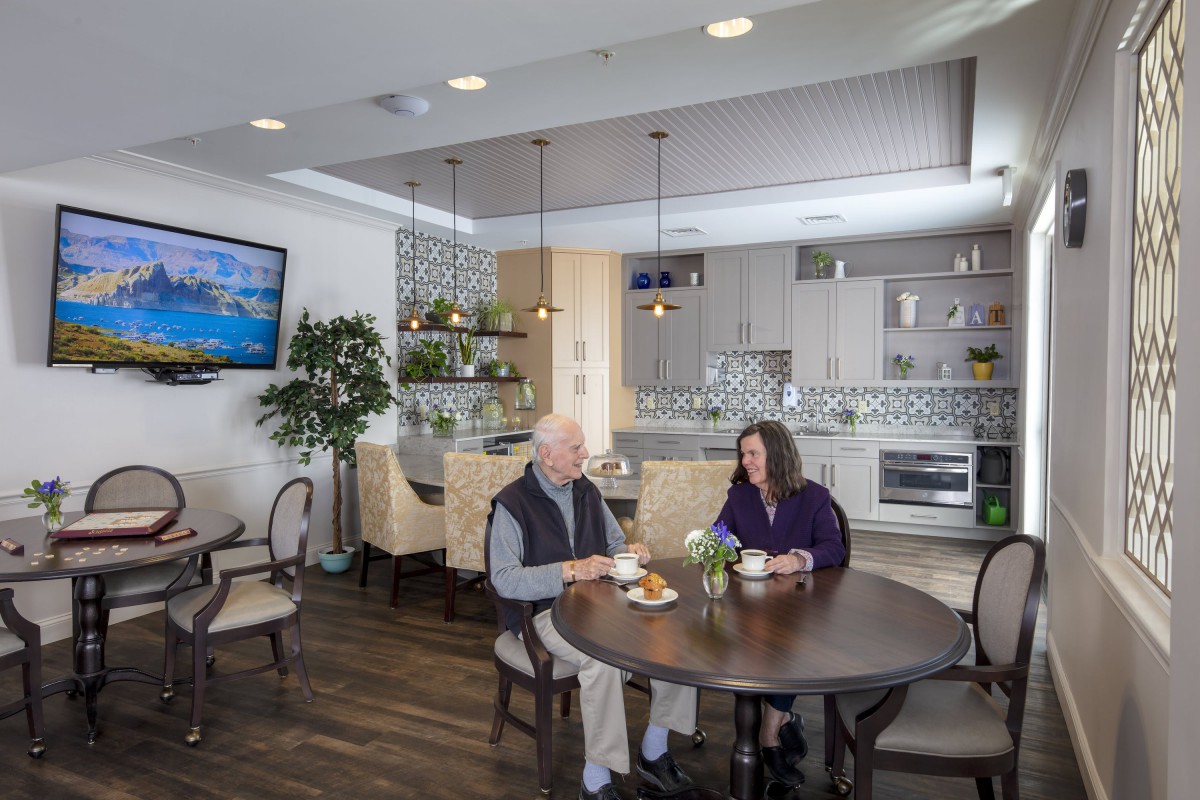 Two people enjoying a meal in a modern kitchen and dining area.