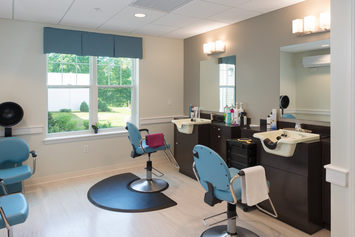 A modern barbershop interior featuring styling chairs, mirrors, and sinks.