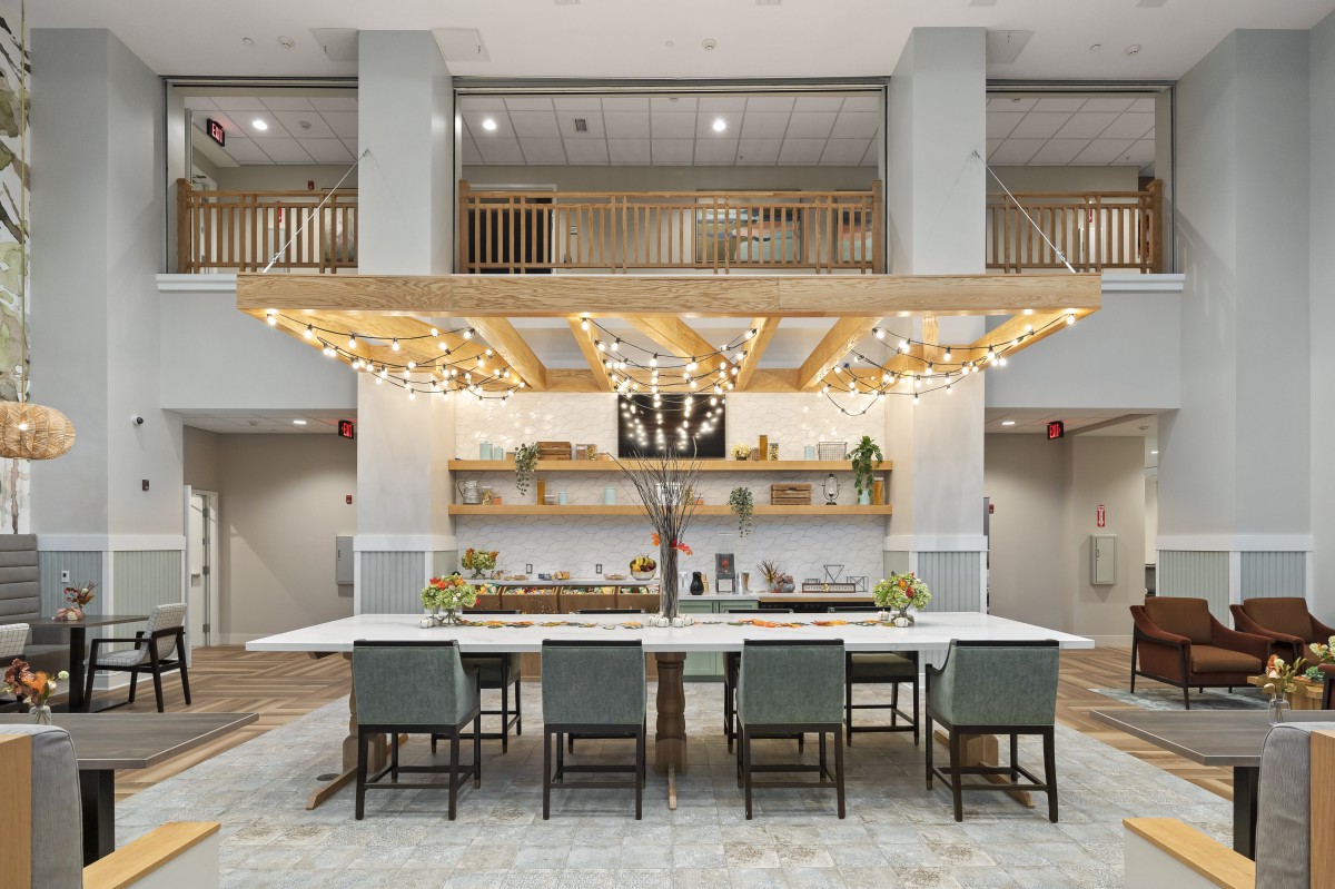 A modern hotel lobby with a stylish seating area, featuring wood accents and decorative lighting.