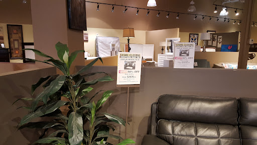 A cozy interior space featuring signage, a plant, and comfortable seating.