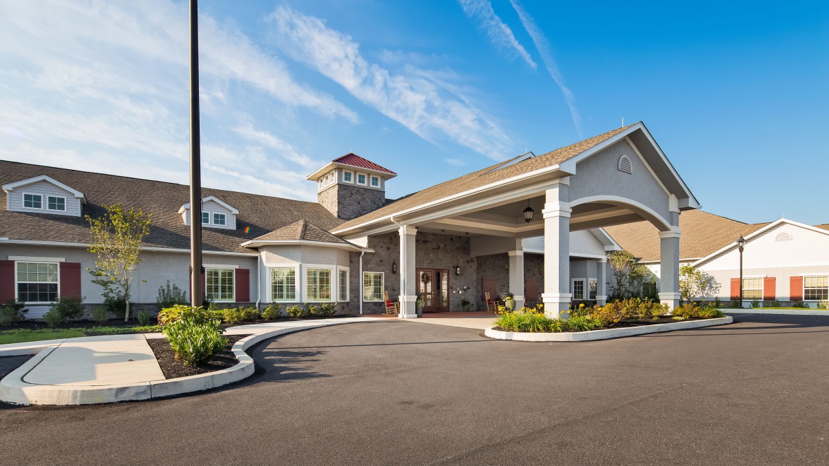 A modern building with a welcoming entrance under a clear blue sky.