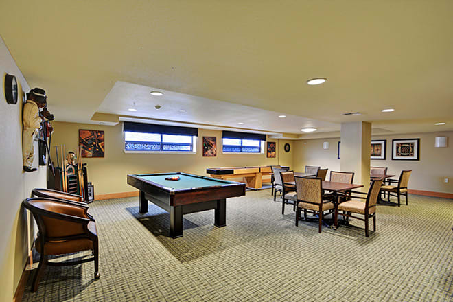 A spacious game room featuring a pool table and seating area.