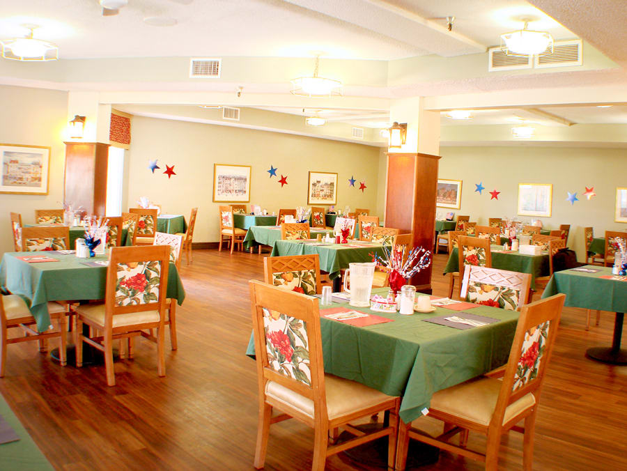A brightly lit restaurant dining area with neatly arranged tables and chairs.