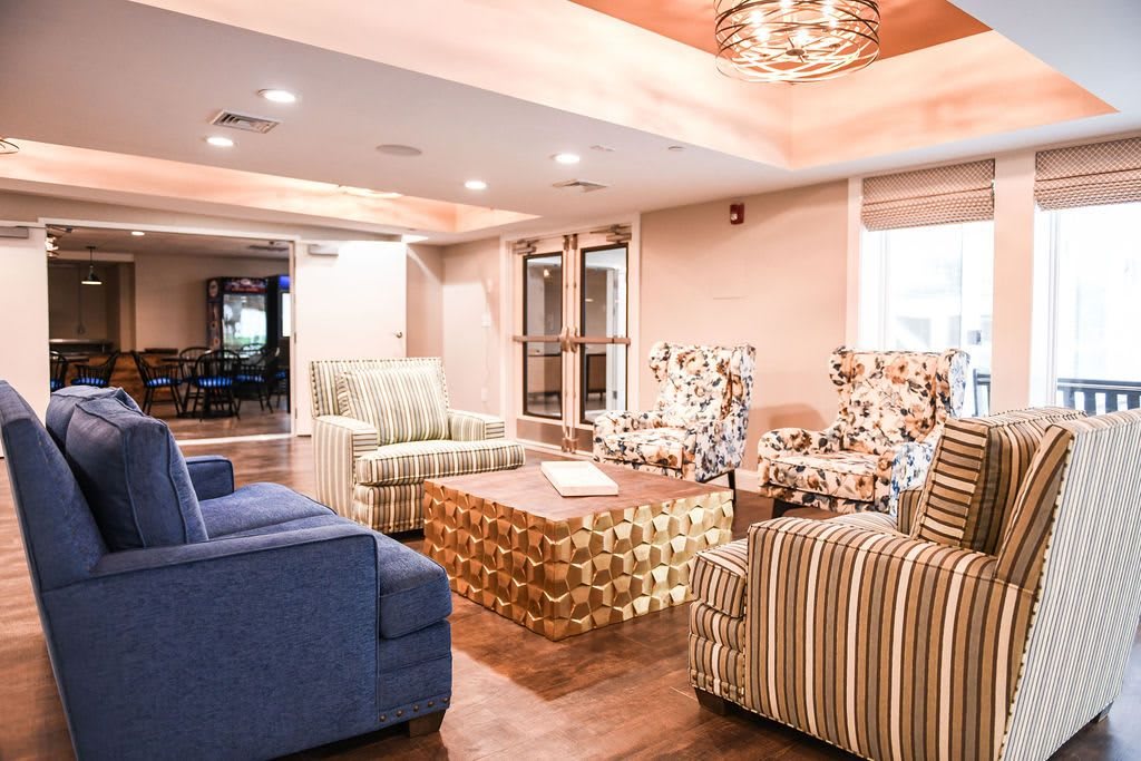 A cozy living room with patterned armchairs and a central coffee table.